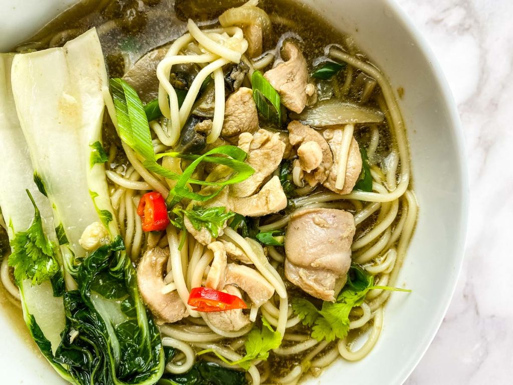 Bowl with broth, chicken, vegetables and noodles.