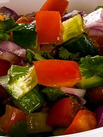 Salad with tomatoes, cucumber, onions and corriander.