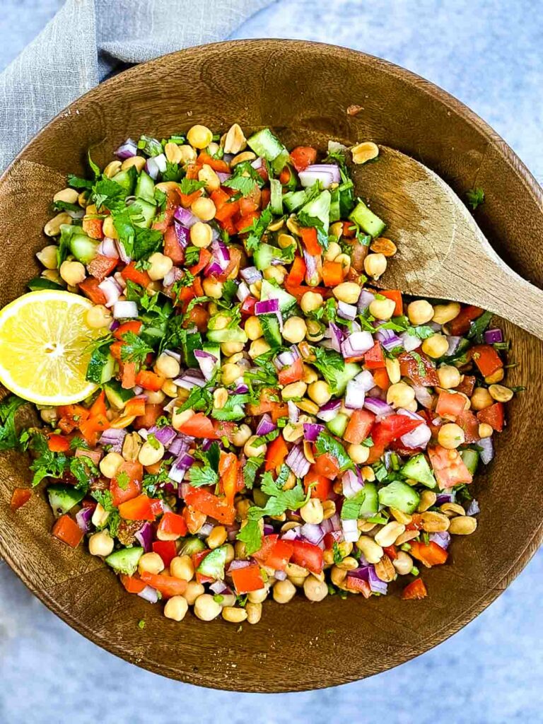 Chickpea salad in a bowl with wooden spoon
