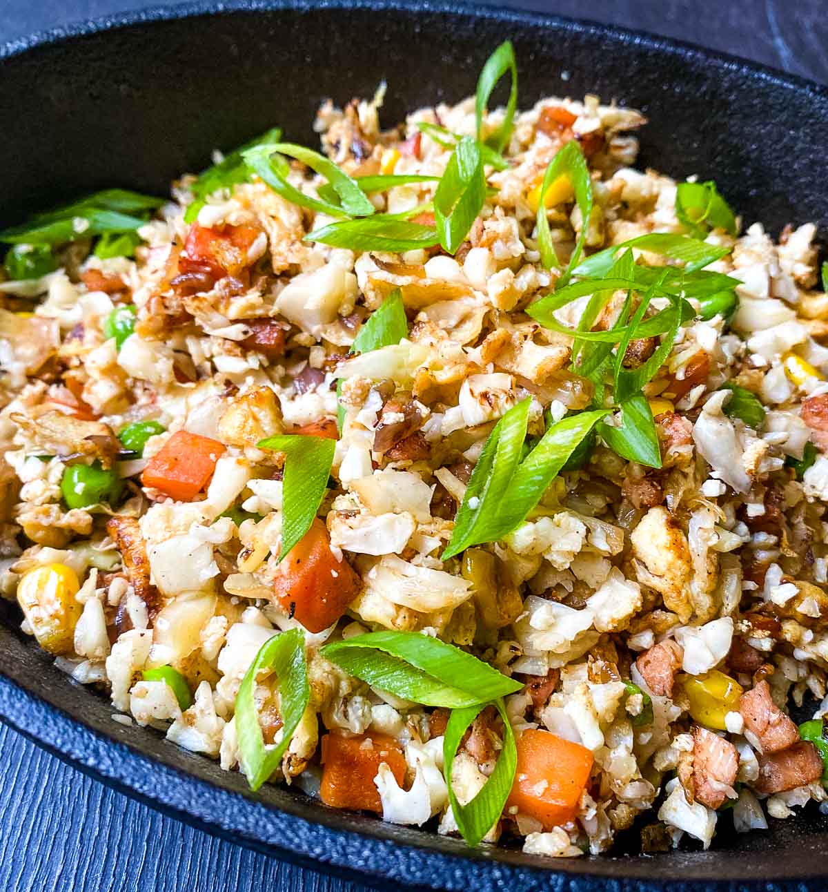 Bowl with cauliflower fried rice with peas, carrots and spring onions