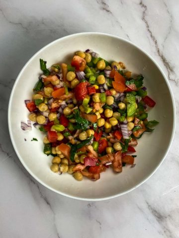 Bowl with chickpeas, tomatoes, red capsicum, red onions, green chilies