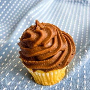 Swirls of chocolate ganache on a cupcake