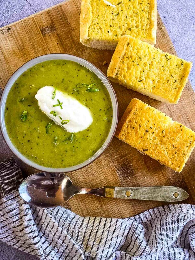 Leek soup with garlic bread on wooden tray