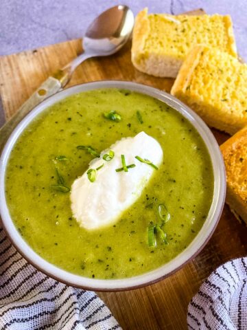 Leek soup with garlic bread on wooden tray
