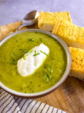 Leek soup with garlic bread on wooden tray