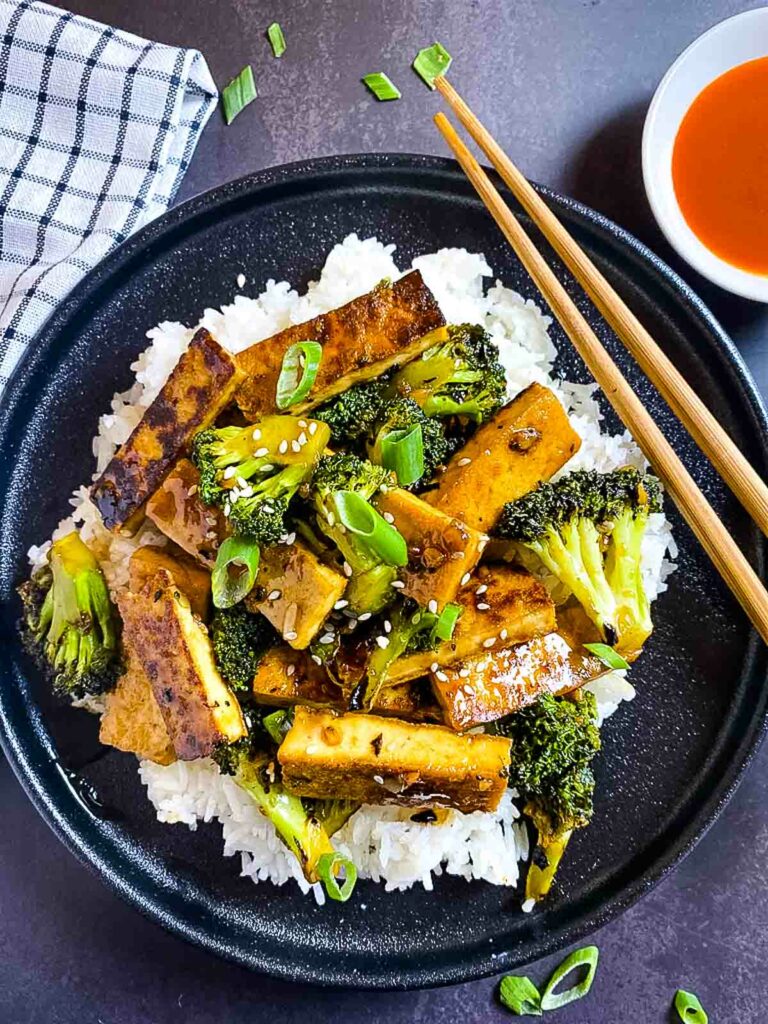Mongolian Crispy Tofu And Broccoli Stir Fry with chopsticks and chilli sauce