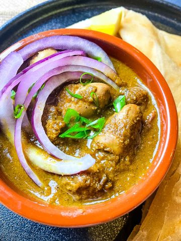 Chicken liver with raw onion in a bowl with roti.