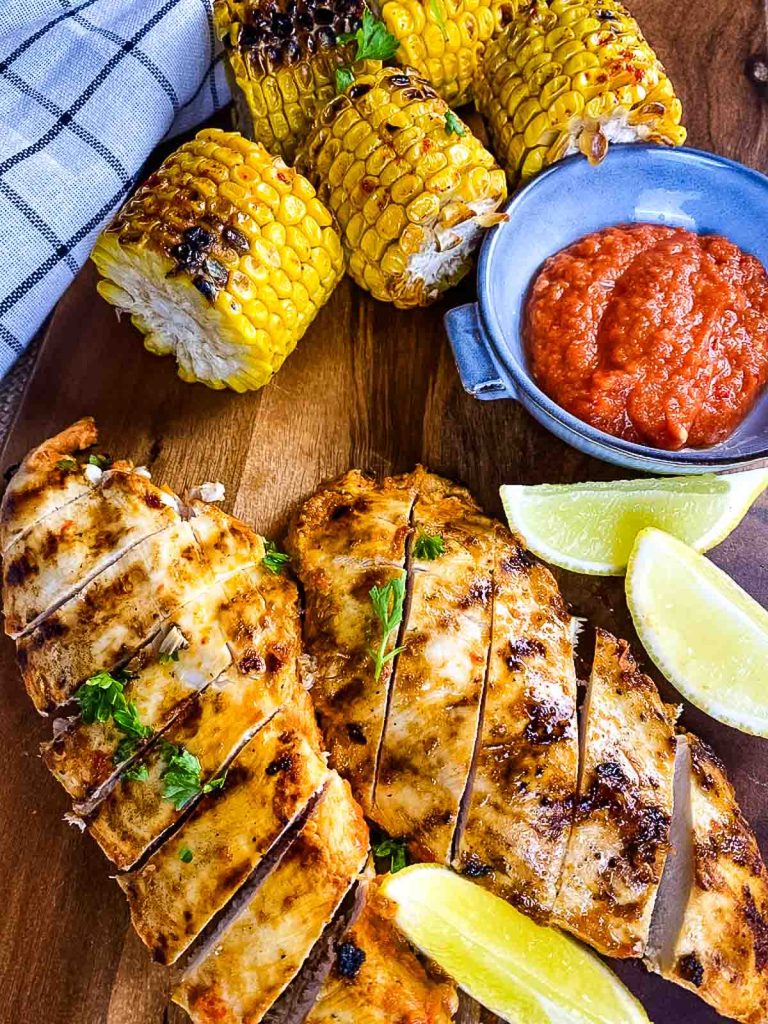 Chicken breast, corn cobs, peri peri sauce and lemon wedges.