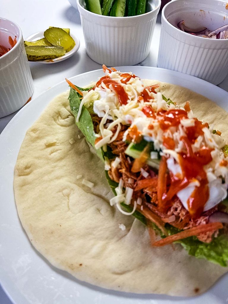 Homemade buffalo sauce drizzled over a chicken vegetable wrap
